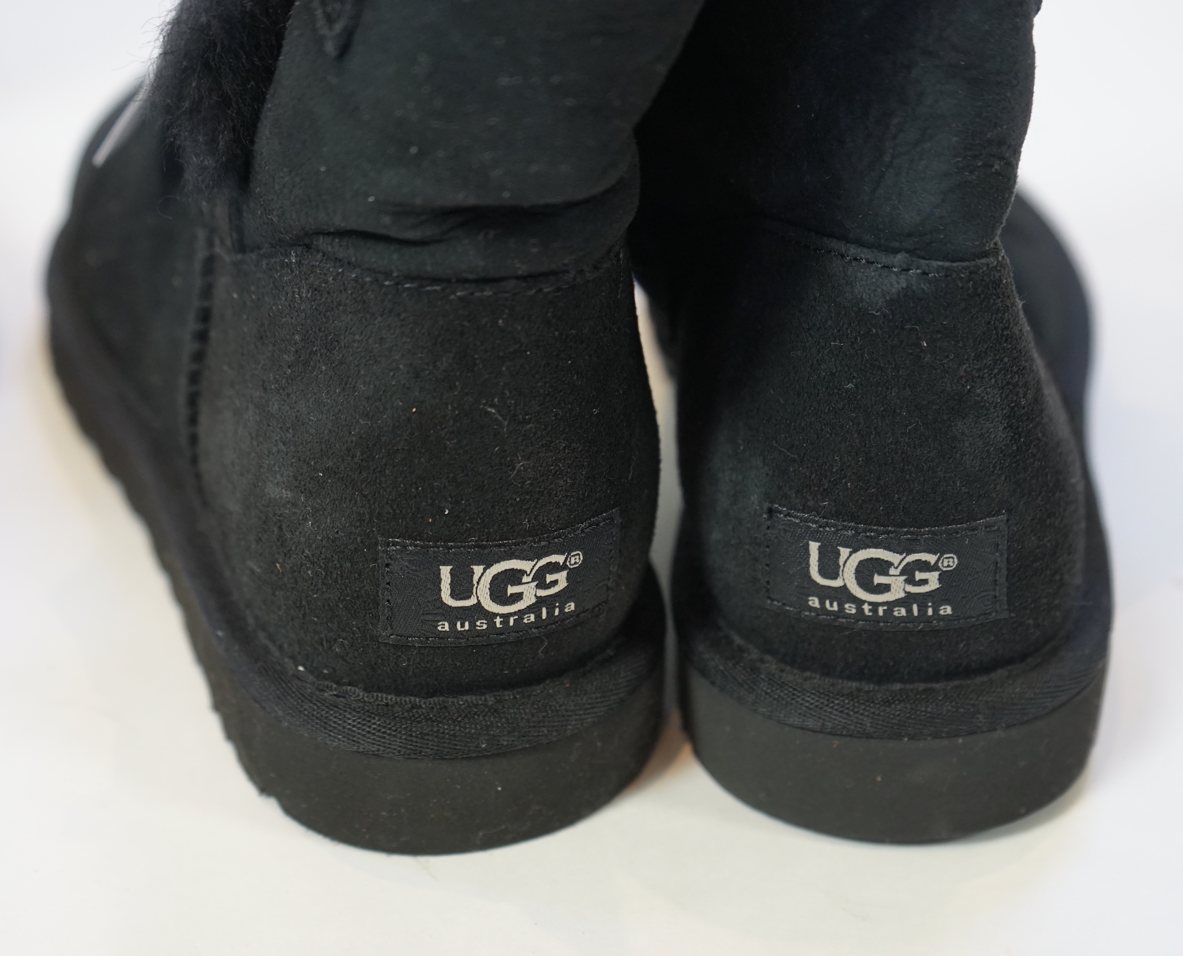 Three pairs of lady's low/mid height UGG sheepskin boots with side button design, size UK 7.5